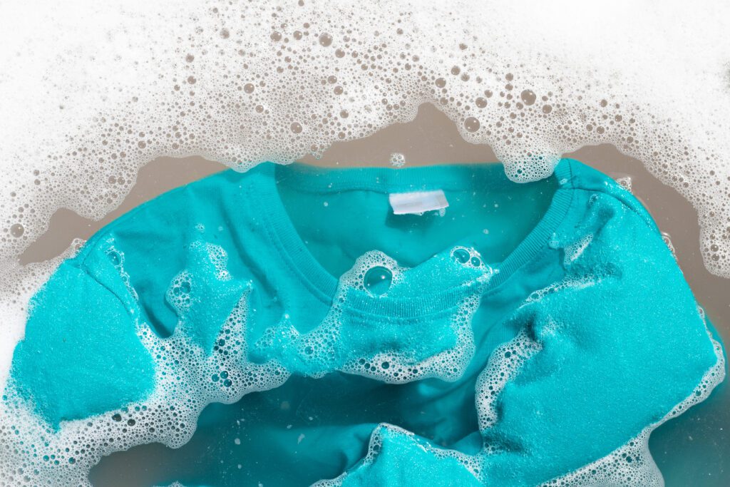 Roupas coloridas sendo lavadas com separação adequada para evitar desbotamento